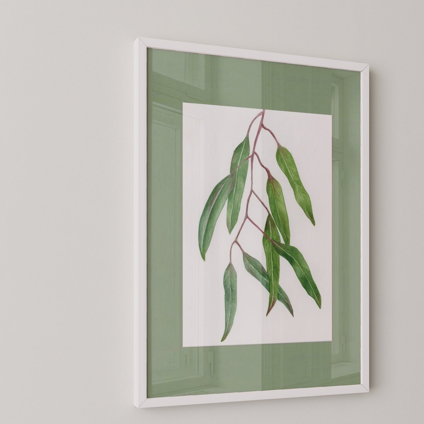 Framed artwork of a green leafy branch on a light gray wall