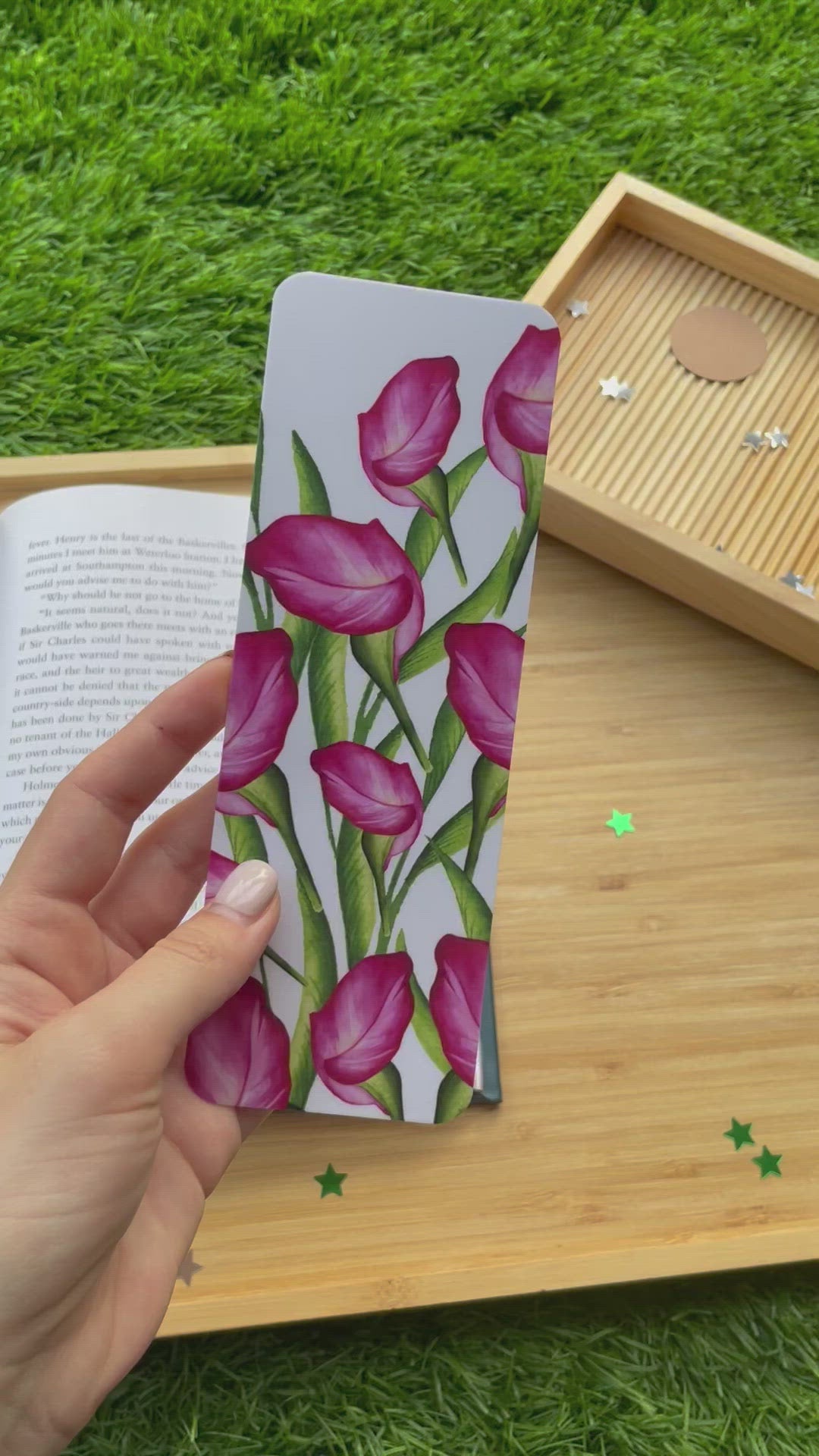 video of a pink lily and greenery watercolor bookmark, being used in a book